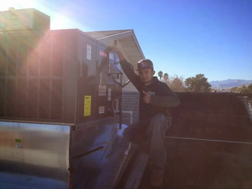 HVAC technician performing Boiler Repair on a rooftop unit in North Reading